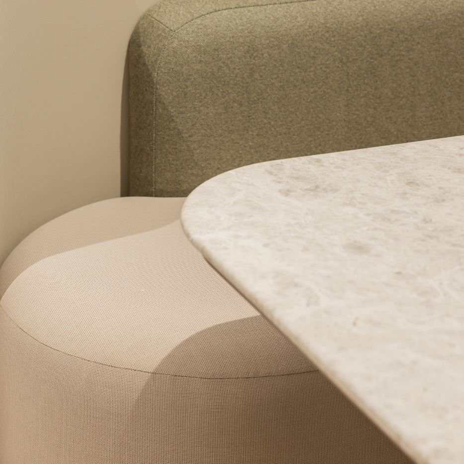 Two toned upholstered bench seating with stone table.